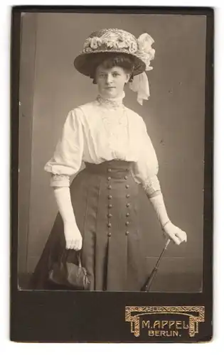 Fotografie M. Appel, Berlin, junge Frau im dunklen Rock mit weisser Bluse und schickem Hut, Handtasche