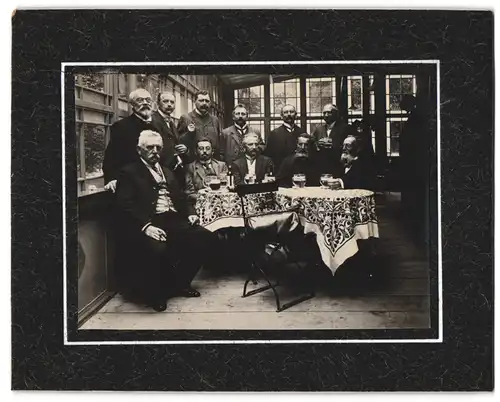 Fotografie unbekannter Fotograf und Ort, ältere Herren in geselliger Runde beim Schwarzbier trinken in einem Lokal
