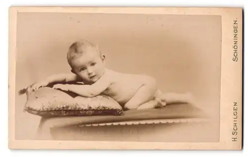 Fotografie H. Schilgen, Schöningen, Am bahnhof, Portrait nacktes süsses Baby auf einem Kissen liegend