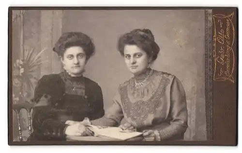 Fotografie Gebr. Otto, Oranienburg, Portrait zwei schöne Damen an einem Tisch sitzend