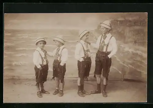 Foto-AK Vier Jungen in Trachtenhosen in einer Studiokulisse