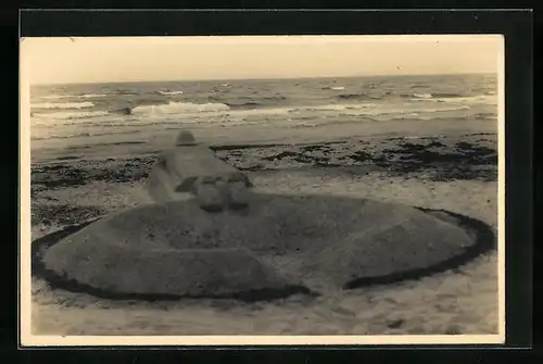 Foto-AK Sandplastik, Soldat liegt bäuchlings am Strand