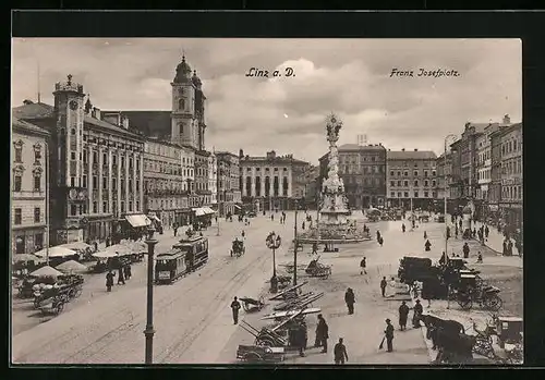 AK Linz a. D., Franz Josef-Platz mit Geschäften und Denkmal, Strassenbahn
