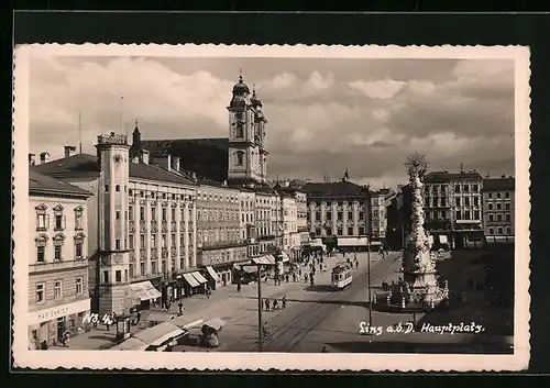 AK Linz a. d. D., Hauptplatz mit Geschäften und Denkmal, Strassenbahn