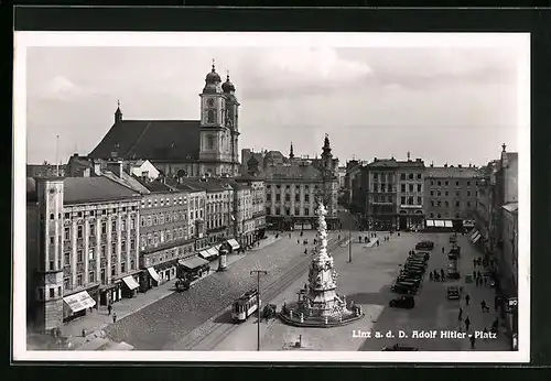 AK Linz a. d. D., Platz mit Geschäften und Denkmal, Strassenbahn