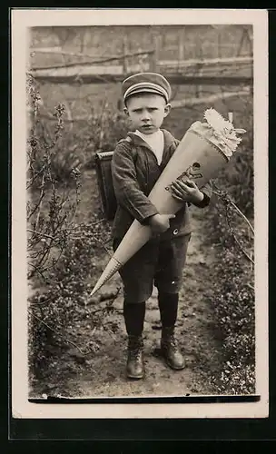 Foto-AK Missmutig blickender Junge beim Schulanfang