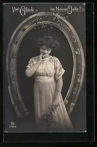 AK Dame mit neckischem Blick unter Hufeisen