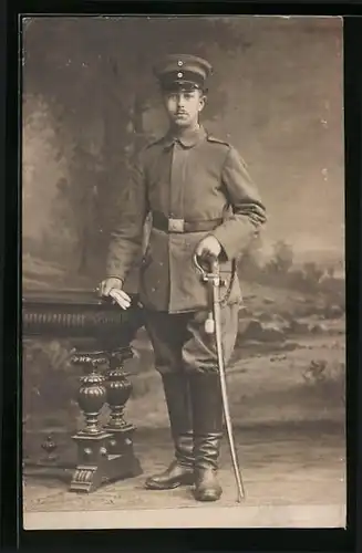Foto-AK Junger Soldat in Feldgrau mit Säbel und Portepee am Säbel