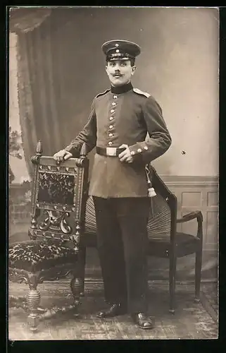 AK Soldat in Uniform, in einem Wohnzimmer stehend