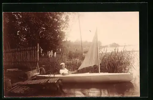 Foto-AK Junger Mann im kleinen Segelboot am Ufer