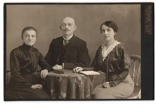 Fotografie Atelier Stern, Dresden-A., Waisenhausstr. 32, Bürgerliches Paar und ältere Dame mit Buch am Tisch