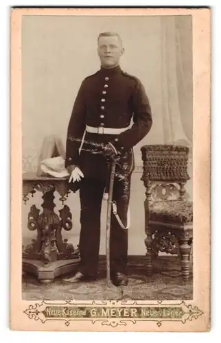Fotografie G. Meyer, Jüterbog, Neue Kaserne, Stolzer Soldat in Uniform auf seinem Säbel lehnend