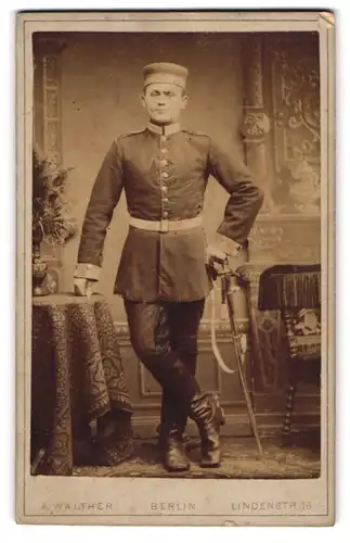Fotografie A. Walther, Berlin, Lindenstrasse 16, Gardist in Uniform mit Krätzchen und Säbel