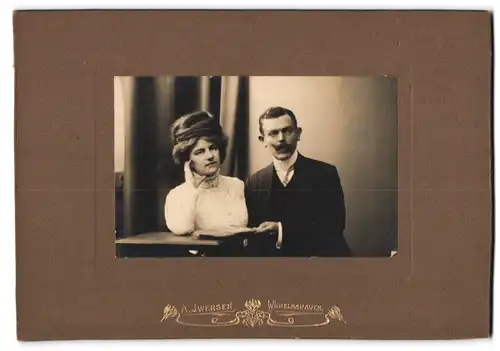Fotografie A. Iwersen, Wilhelmshaven, Bürgerliches Paar mit einem Album