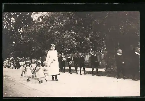 Foto-AK Dienstmädchen beim Spaziergang mit mehreren Kindern