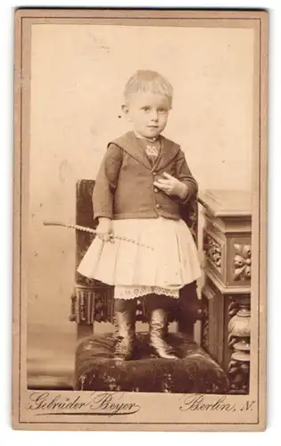 Fotografie Gebrüder Beyer, Berlin-N., Schönhauser Allee 6, Modisch gekleidetes Kind mit Peitsche