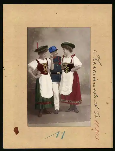 Fotografie Brück & Sohn Meissen, Ansicht Theresienstadt, Damen in Tracht mit K.u.K. Soldat in Uniform, Hand Koloriert