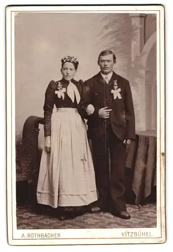 Fotografie A. Rothbacher, Kitzbühel, Junges Hochzeitspaar in schwarzer Festtagskleidung mit weissen Schleifen