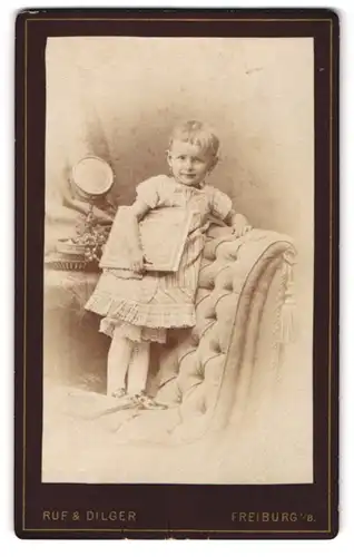 Fotografie Ruf & Dilger, Freiburg i. B., Ludwigstr. 2, Stolzes kleines Mädchen auf einem Stuhl stehend