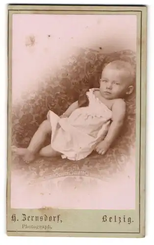 Fotografie A. Bernsdorf, Belzig, Baby im Strampelkleid auf einem Sitzmöbel