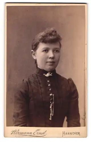 Fotografie Hermann Ernst, Hannover, Junge Frau mit üppigen Stirnlocken und Vogelbrosche