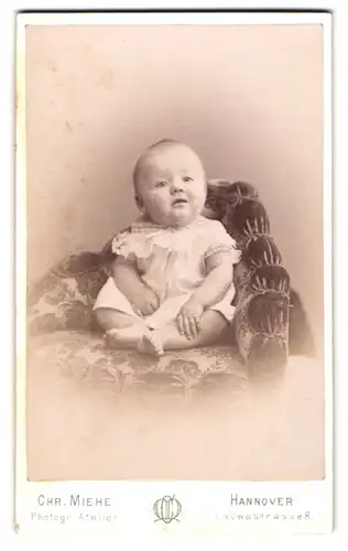 Fotografie Chr. Miehe, Hannover, Lavesstrasse 8, Aufgewecktes Baby auf einem Sitzmöbel