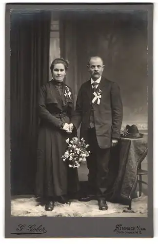 Fotografie G. Gober, Simbach a. Inn, Dultstr. 2, Bürgerliches Paar in hübscher Kleidung mit Blumenstrauss