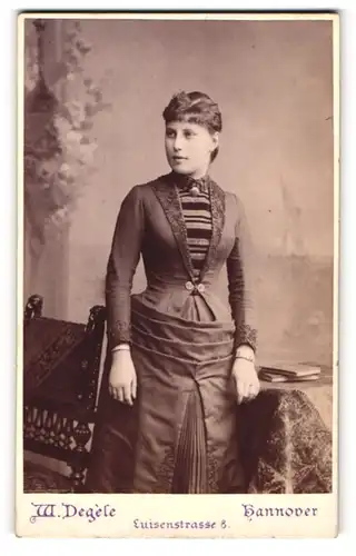 Fotografie W. Degele, Hannover, Luisenstr.8, Selbstbewusste junge Frau in feinem Kleid mit Brosche