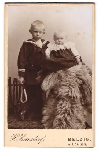 Fotografie H. Zernsdorf, Belzig, Sandbergerstr. 23, Kleiner Junge in modischer Kleidung mit Kleinkind