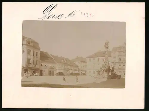 Fotografie Brück & Sohn Meissen, Ansicht Dux, Marktplatz mit Dreifaltigkeitssäule mit Geschäften