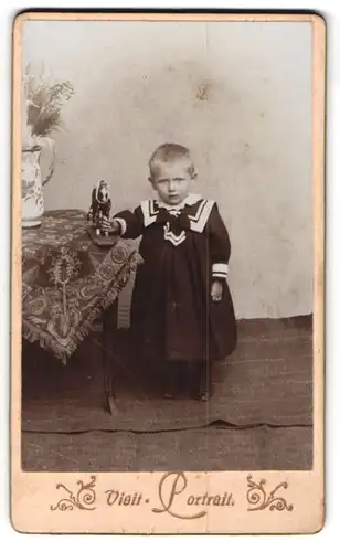 Fotografie unbekannter Fotograf und Ort, Kleines Kind mit Spielzeugpferd in weitem Kleid