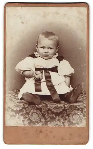 Fotografie unbekannter Fotograf und Ort, Kleines Kind mit Ball in festlichem Kleidchen