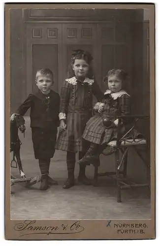 Fotografie Samson & Co., Nürnberg, Karolinenstr. 45, Drei Kinder neben einem Schaukelpferd