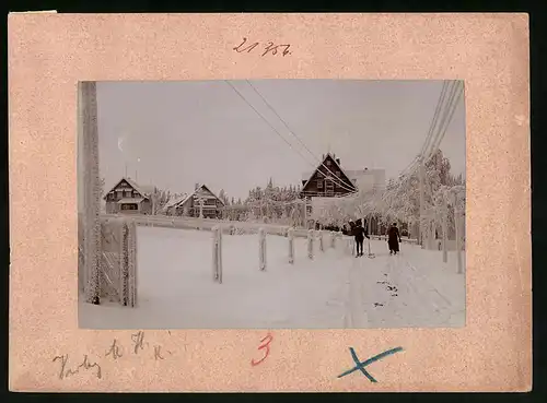 Fotografie Brück & Sohn Meissen, Ansicht Oberbärenburg i. Erzg., Skiläufer im Ort bei strengem Winter, zugeschneit