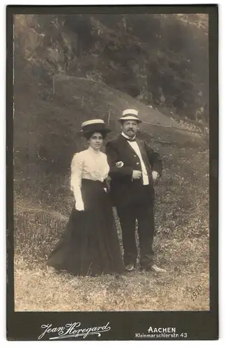 Fotografie Jean Horegard, Aachen, Kleinmarschierstrasse 43, Fröhliches Paar mit Strohhüten auf einer Wiese