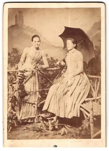 Fotografie unbekannter Fotograf und Ort, Zwei junge Frauen mit weiten Röcken und Regenschirm 
