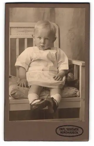 Fotografie Carl Schiewek, Nordhausen, Töpfer Str. 1, Kleinkind im Kleid auf dem Stuhl