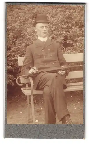 Fotografie unbekannter Fotograf und Ort, Mann mit Melone und Schirm auf einer Bank sitzend