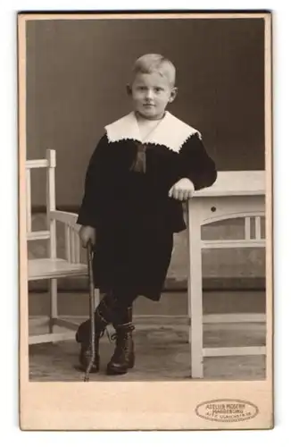 Fotografie Hugo Paulsen, Magdeburg, Alte Ulrichstrasse 18, Kleiner Junge mit karierter Hose an Tisch anlehnend