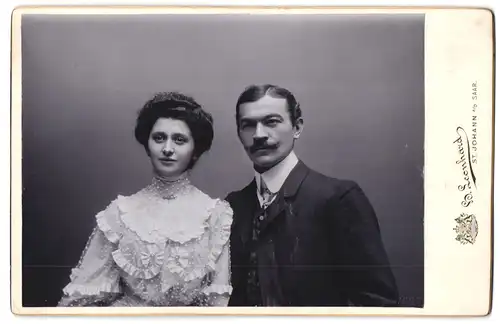 Fotografie H. Leonhard, St. Johann /Saar, Bahnhofstrasse 83, Junge Dame in Rüschenbluse und junger Herr mit Schnurrbart