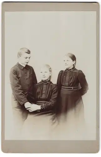 Fotografie unbekannter Fotograf und Ort, Halbwüchsiger Knabe mit zwei jungen Mädchen in modischer Kleidung