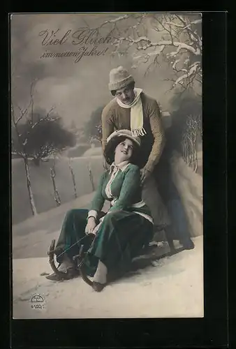 AK Junges Paar mit Schlitten im Schnee