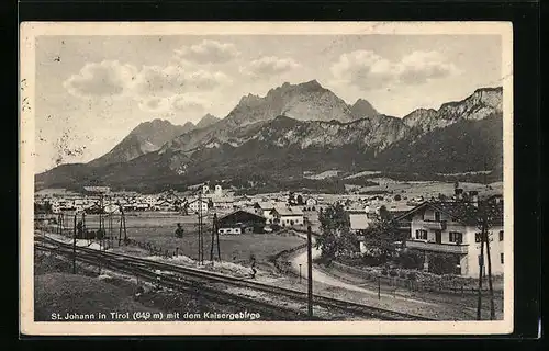 AK St. Johann, Ortsansicht mit Bahnschienen und dem Kaisergebirge