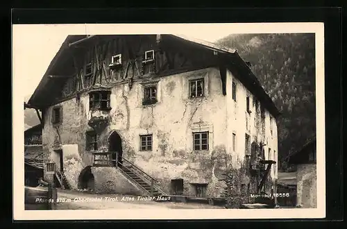 AK Pfunds, Altes Tiroler Haus mit bewaldetem Berg