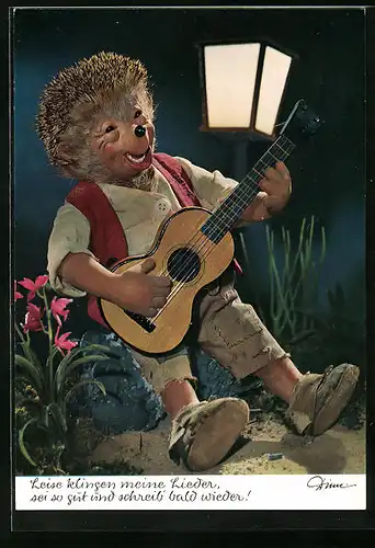 AK Mecki sitzt unter einer Laterne und spielt auf seiner Gitarre