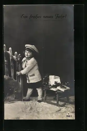 AK Kleines Mädchen mit Päckchen auf Schlitten im Winter, Neujahrsgruss