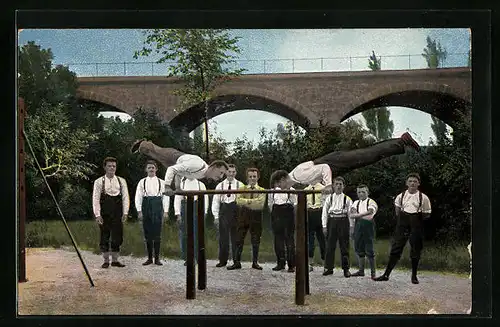 AK Herren beim Turnen am Barren unter einer Brücke