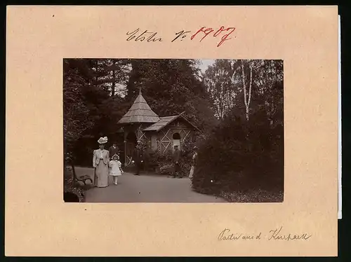 Fotografie Brück & Sohn Meissen, Ansicht Bad Elster, Holzhütte im Kurpark mit Soldat und Spaziergängern