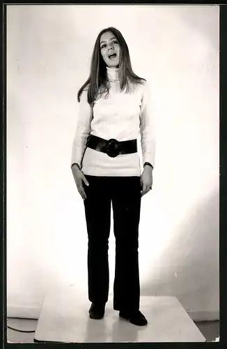 Fotografie hübsche junge Dame trägt schwarze Hose & helles Oberteil mit Rollkragen