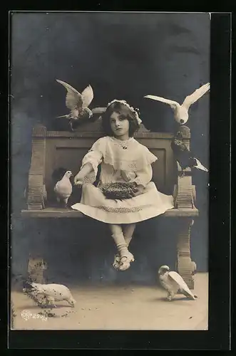 Künstler-AK Mädchen auf einer Bank füttert Tauben